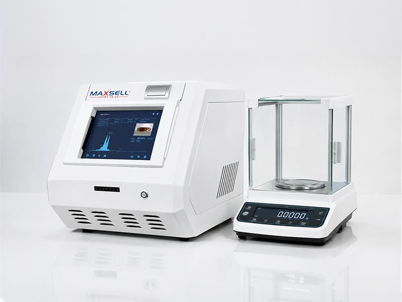 Gold items placed in a professional testing machine with a digital weighing scale beside it